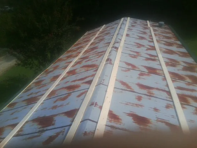 Rusted metal roof panels with new wood purlins before replacement — Storm Damage Roof Repair in Buffalo Valley by Roofing Brothers