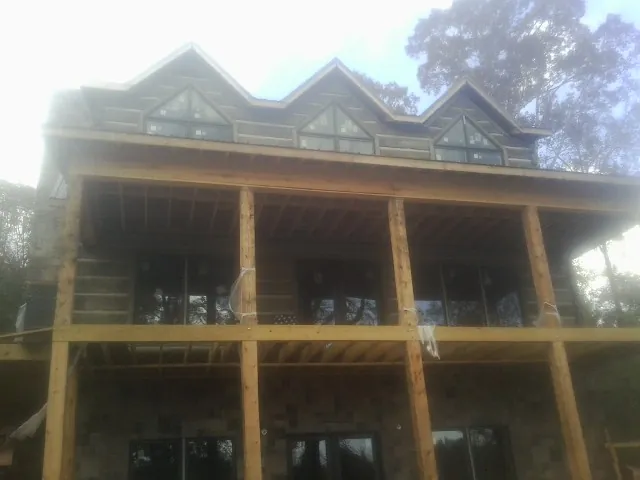 Dormers and porch framing on a large log home under construction — Roof Coating work by our crew in Buffalo Valley