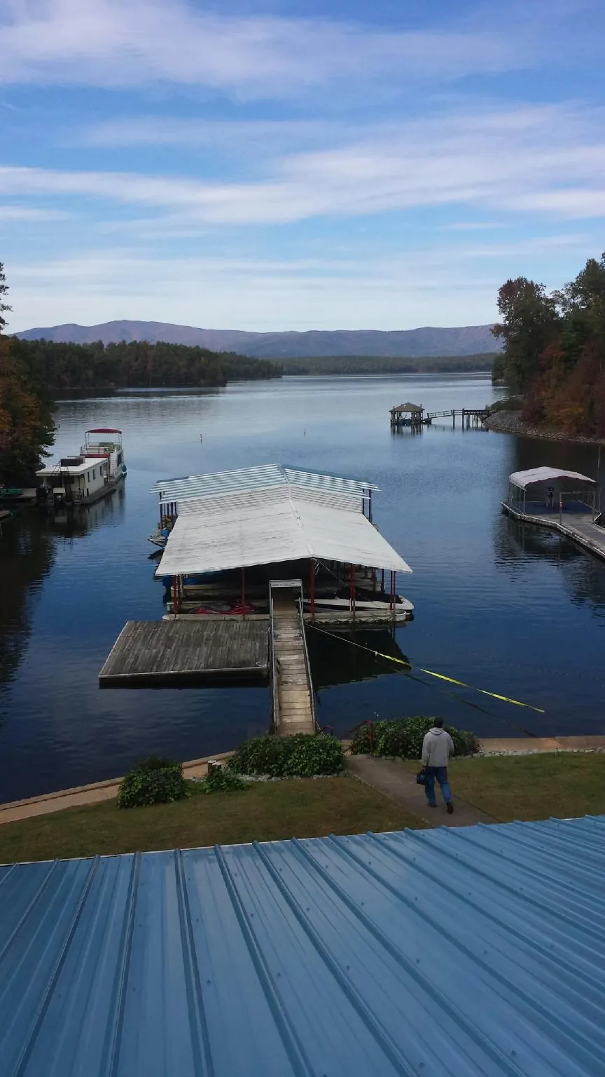 View across a lake from a newly installed blue metal roof in Buffalo Valley