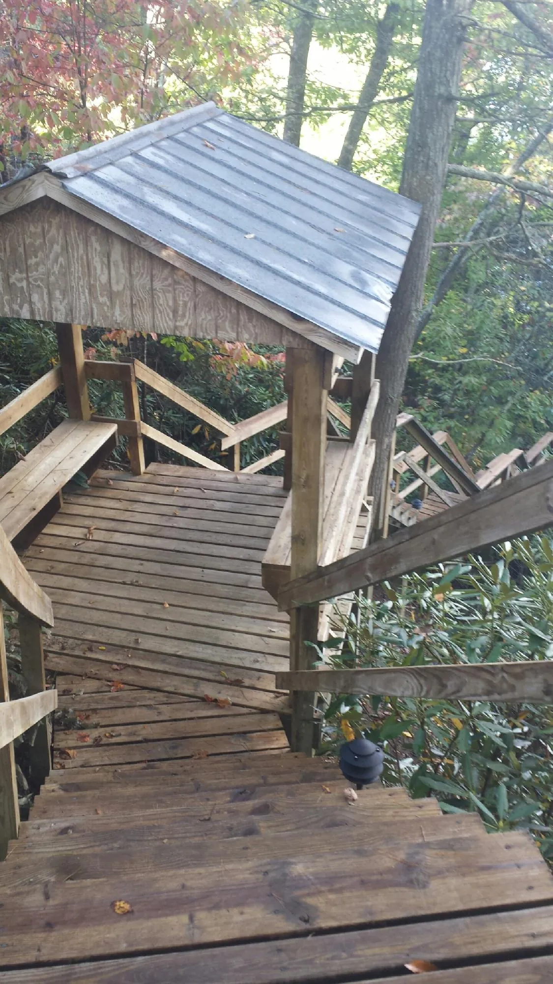 Metal roofed shelter over wooden steps on a wooded walkway — Skylight Repair & Installation work by our crew in Buffalo Valley