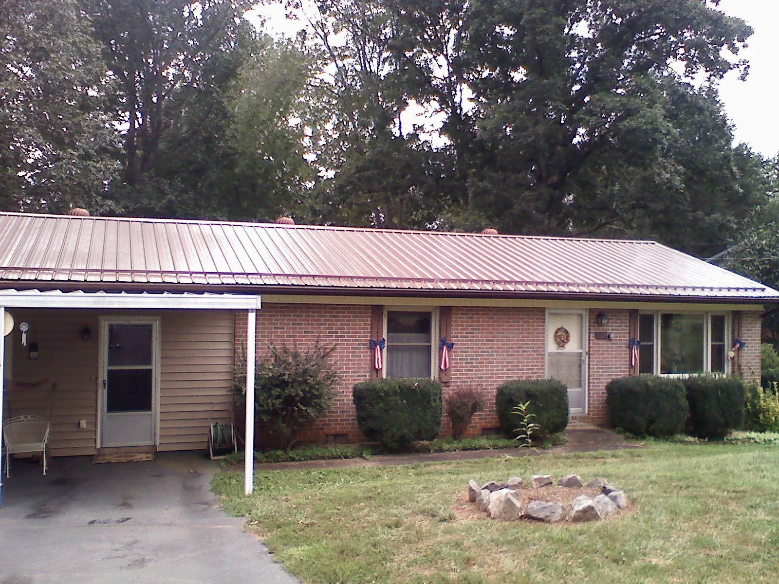 Bronze metal roof and carport on a brick ranch home — Roof Repair work by our crew in Buffalo Valley
